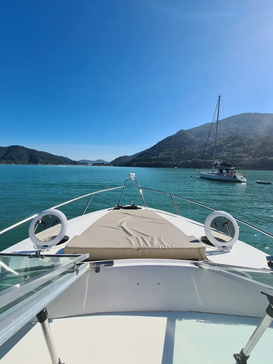 Embarcação navegando entre o mar e as montanhas de Ubatuba