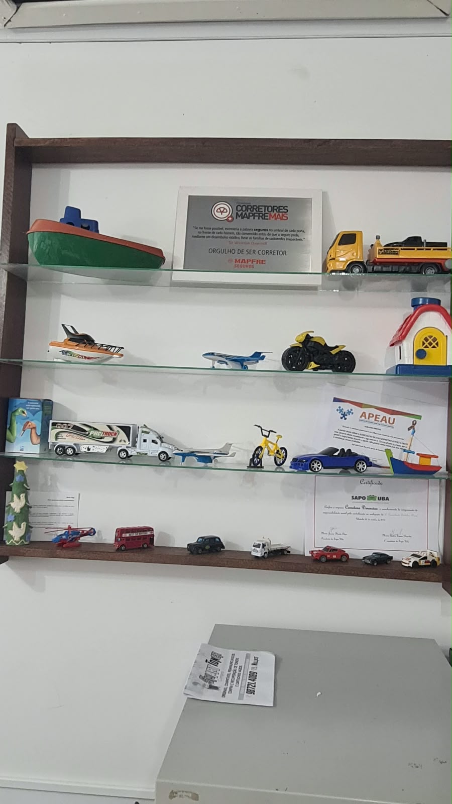 Miniaturas de barcos e veículos em uma estante, imagem de apoio para falar sobre patrimônio e equipamentos